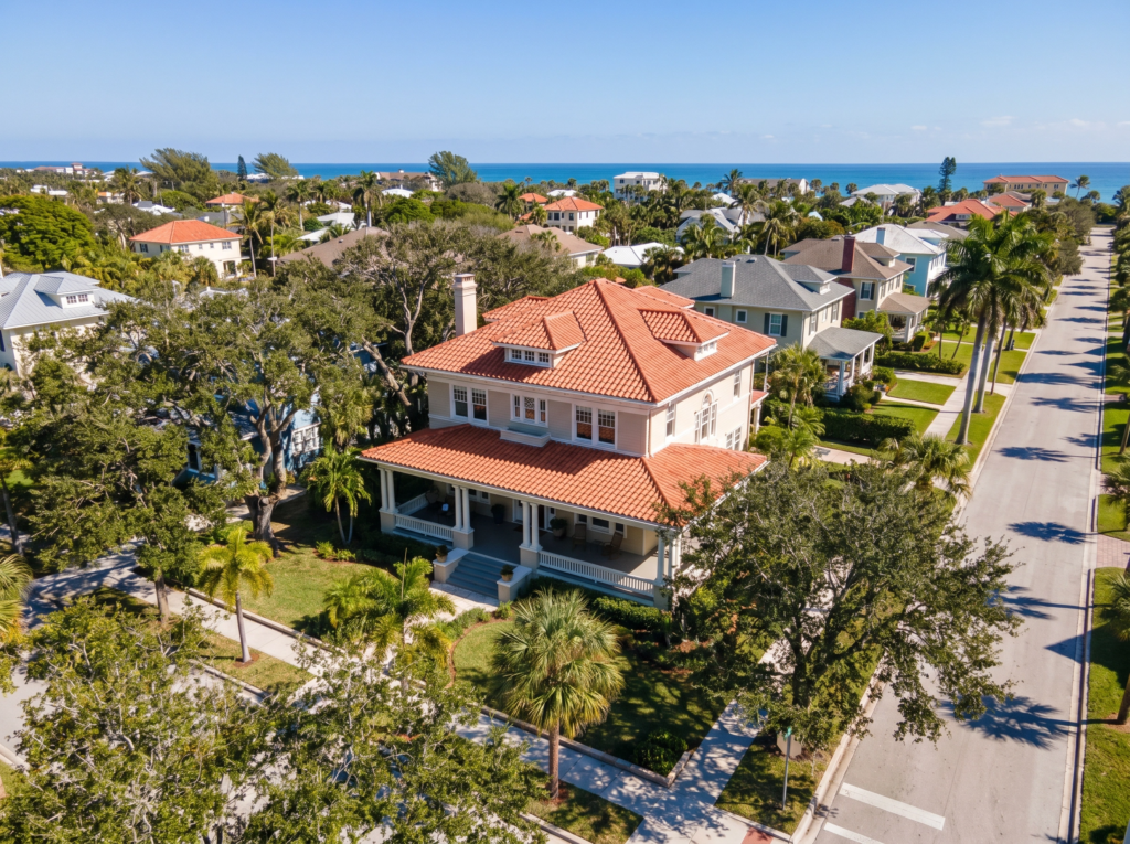 Aerial view of a historic Lake Worth Beach neighborhood featuring a large residence with a premium terracotta tile roof near the coast.