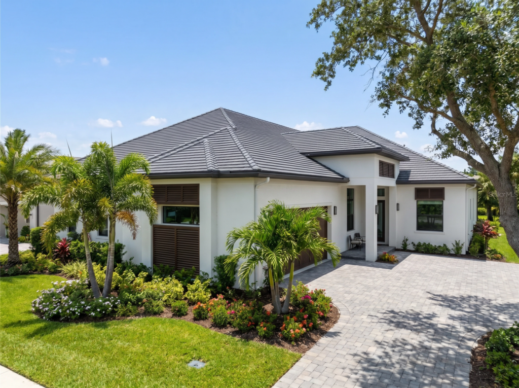 A modern single-family home in Lake Worth, FL, featuring a pristine dark grey concrete tile roof and professional landscaping.