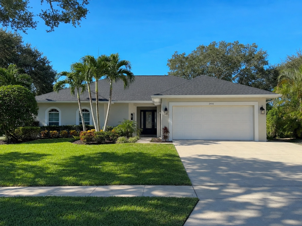 A clean, beige single-family home in Greenacres with a new charcoal shingle roof and palm trees.